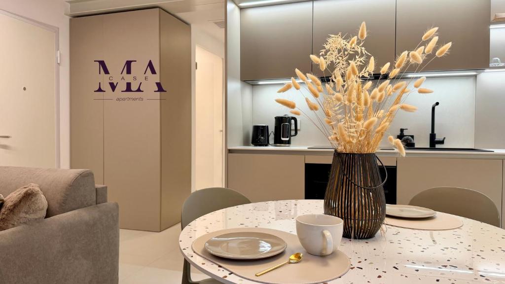 a dining room with a table with a vase of flowers at MAcase Apartments in Ferrara