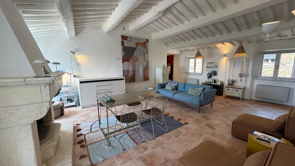 a living room with a blue couch and a table at SuSuMare in Campiglia Marittima