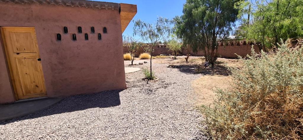 a door to a house with sheep in a yard at Cabaña Laynaturi in San Pedro de Atacama