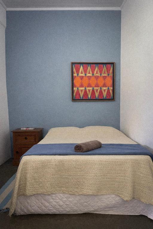 a bed in a bedroom with a painting on the wall at Suite 3 in São Domingos