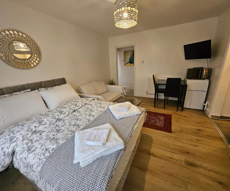 a bedroom with a bed and a living room at Lovely studio flat in Reading