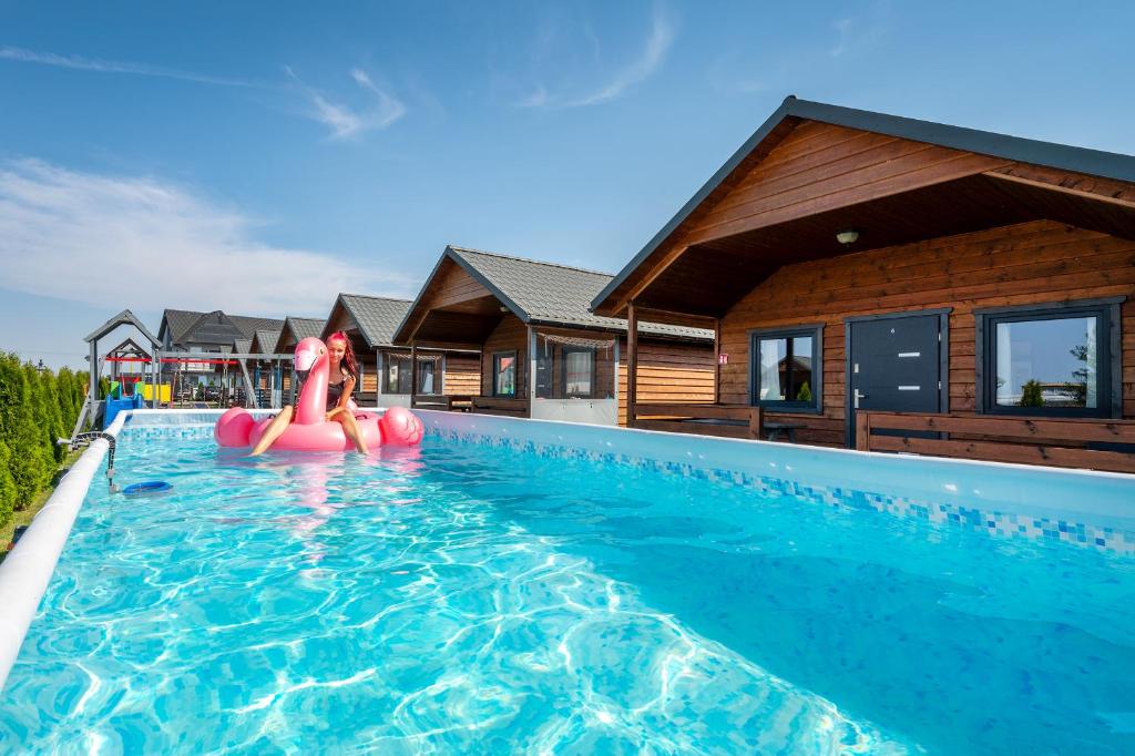 a large swimming pool with a pink inflatable at Domki Agnes in Darłowo