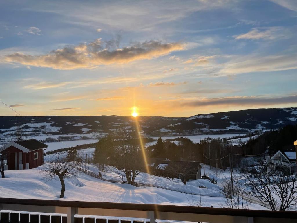 a winter sunset with the sun shining on the snow at Toppen House in Ringsaker