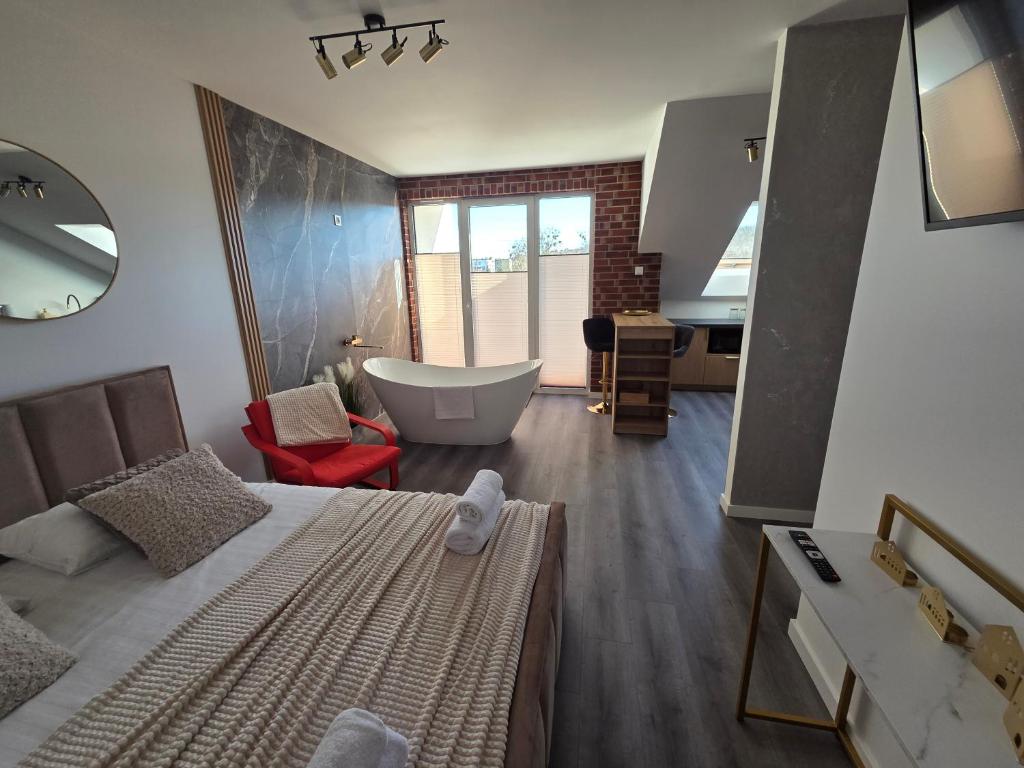 a bathroom with a tub and a bed and a sink at Golden Heaven z wanną in Lębork