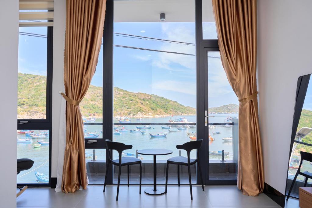 a room with a table and chairs in front of a window at Hotel Vũng Găng in Vĩnh Hy