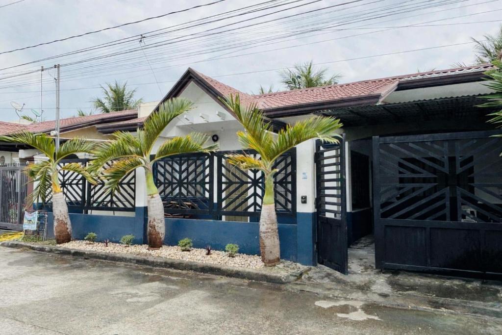 a house with palm trees in front of a garage at Sim's Agan South Villas in Lagao III