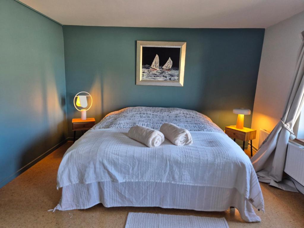 a bedroom with a bed with two pillows on it at Chambre de Arnaud à Gerpinnes in Gerpinnes