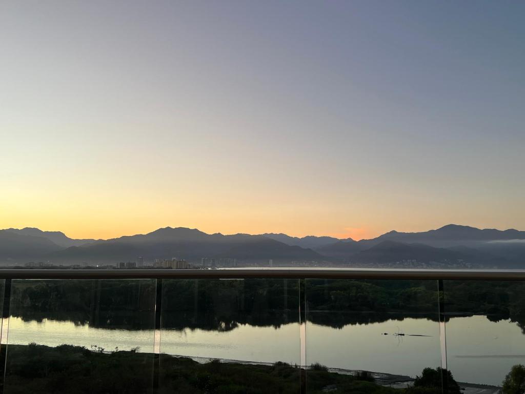 a sunset over the water with mountains in the background at Vidanta World in Jarretadera