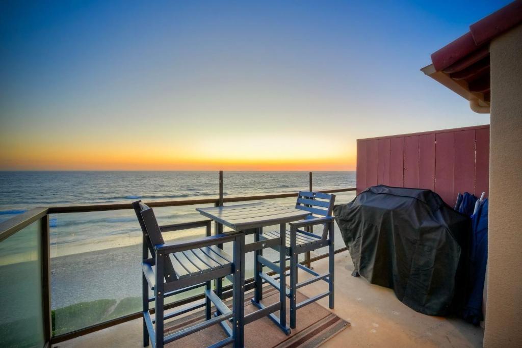 a table and chairs on a balcony with the ocean at Oceanfront Condo, Private Balcony, Beach Access, Sunset Views in Carlsbad