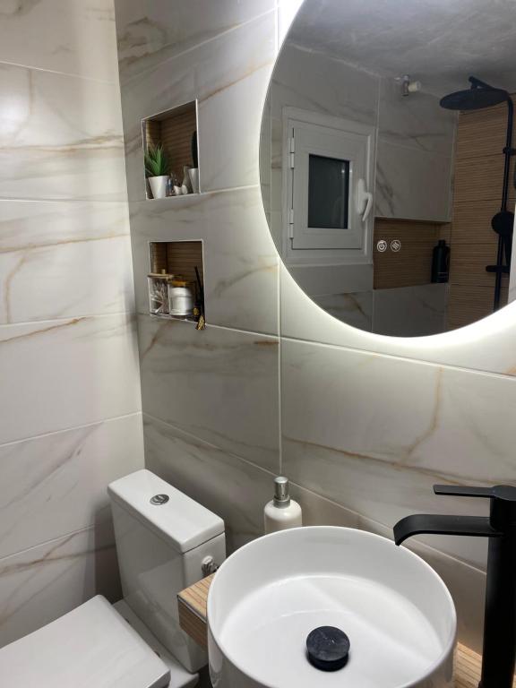 a bathroom with a white sink and a mirror at Casa de Elena Marousi in Athens