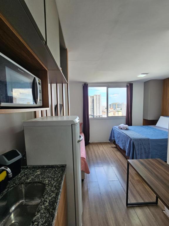 a hotel room with a bed and a sink at 200m metro bras com Piscina in São Paulo