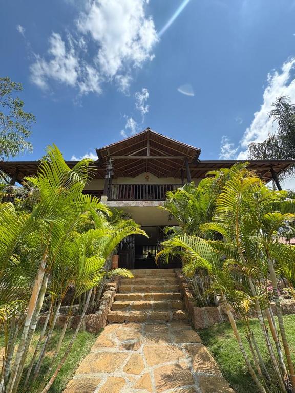 a house with palm trees in front of it at Cabaña Barichara in Barichara