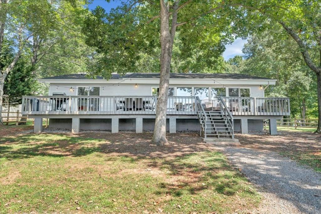 a large white house with a porch and a ladder at Summer Breeze - Lakefront w/ Private Dock! in Moneta
