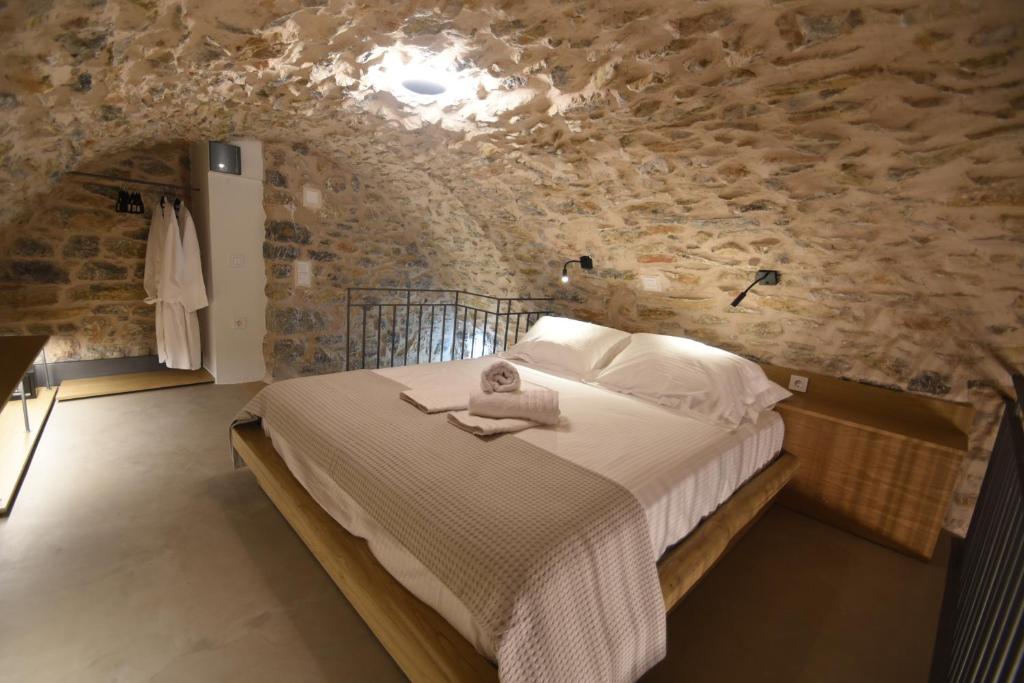a bedroom with a bed in a stone wall at Armathia Accommodation in Mestá