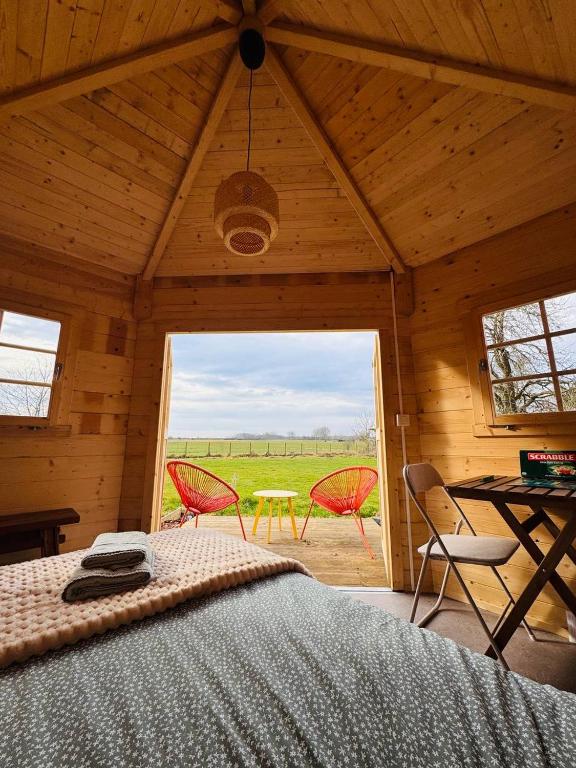 a bedroom with a bed and two chairs in a room at The Bee Garden - Cosy Cabin in Lede