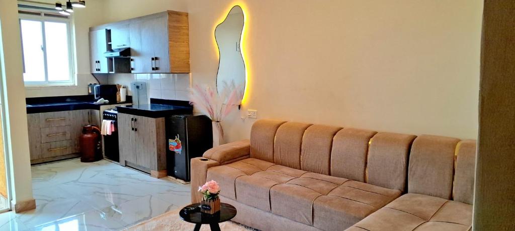 a living room with a couch and a kitchen at Nuellas Haven in Kira