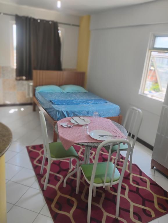a room with a table and chairs and a bed at Flat Bonito e Confortável in Campos dos Goytacazes