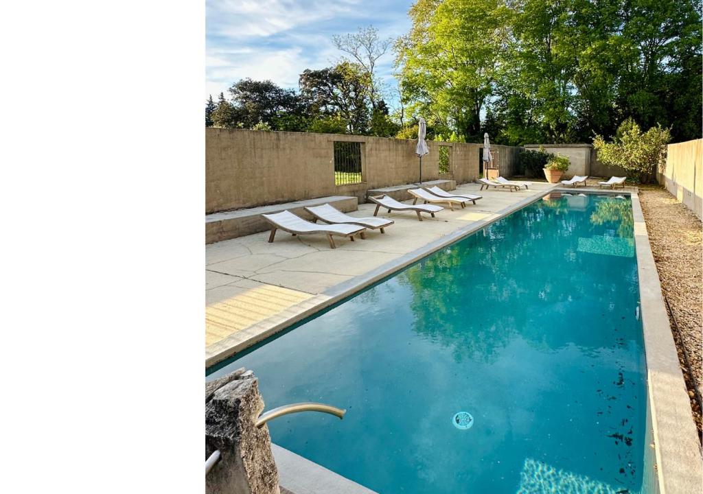 a swimming pool with chaise lounge chairs and a swimming pool at Les Madones in Nîmes