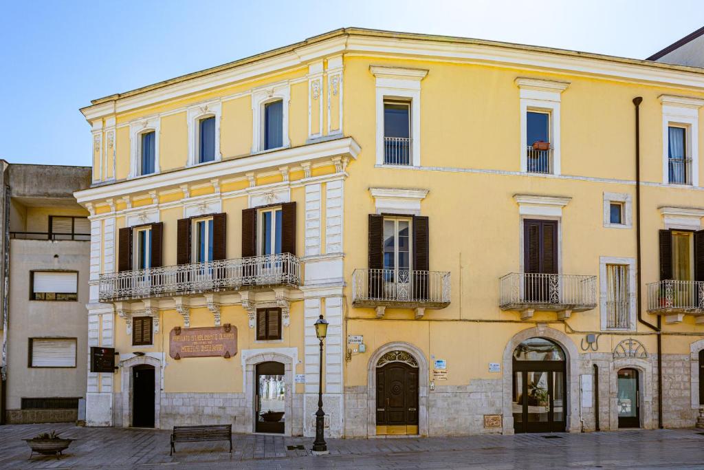 a yellow building with balconies on a street at Dimora Storica Palazzo Didonna in Rutigliano