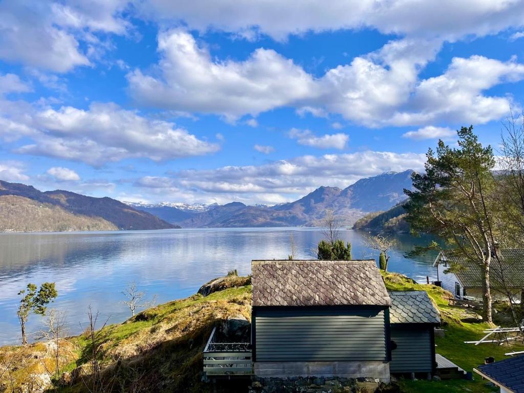 a house on a hill next to a body of water at Villa Vannes in Skånevik