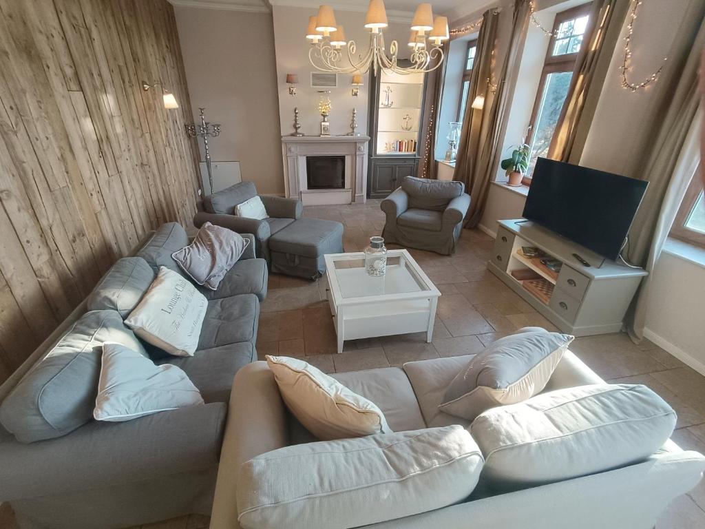 a living room with a couch and a tv at Bauernhaus Premium in Fehmarn