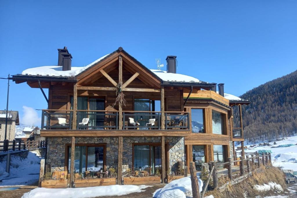 a log home in the mountains with snow at Green Hospitality Monolocale Stella Alpina in Livigno