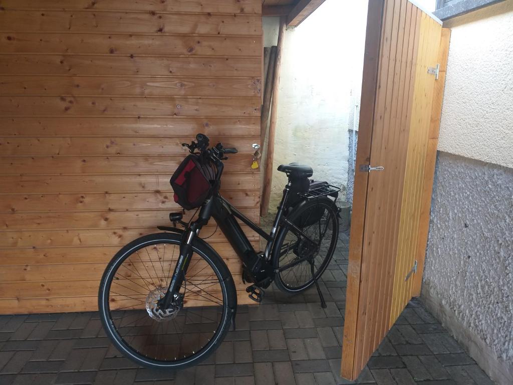 a bike parked next to a wooden wall at Apartment Zwei Schlafzimmer und absperrbare Fahrradgarage in Baumholder