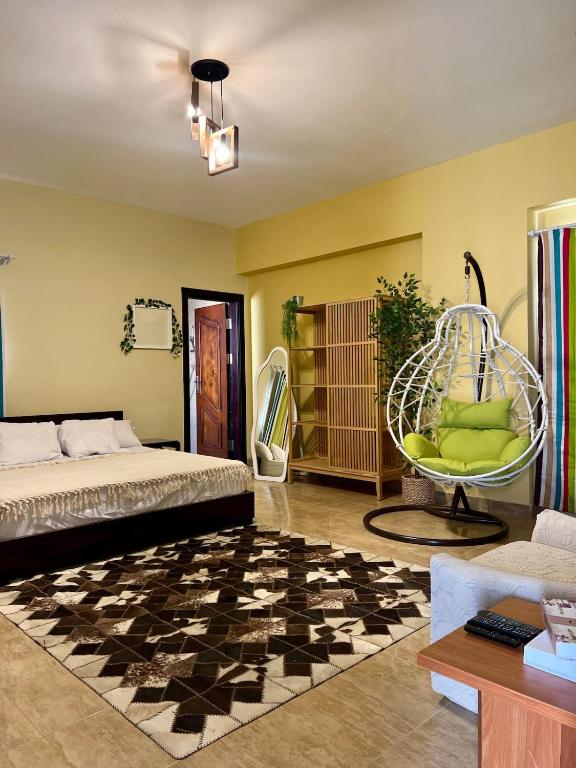 a bedroom with a bed and a chair in a room at Yousrys Nest Cozy Rooftop Studio in New cairo