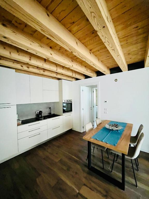 a kitchen with white cabinets and a wooden table at A Casa di Angelica in Piovene Rocchette