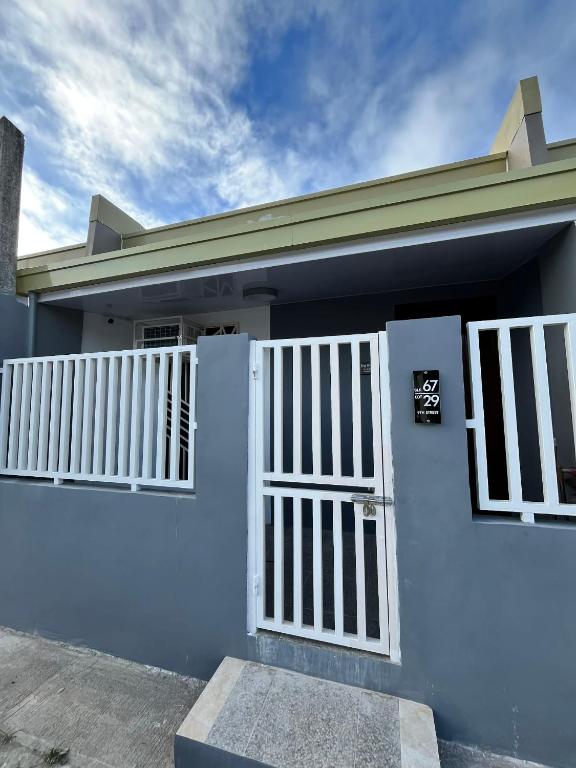 a blue house with a white gate at Log Horizon by The Guild Oasis Transient House in Rosario