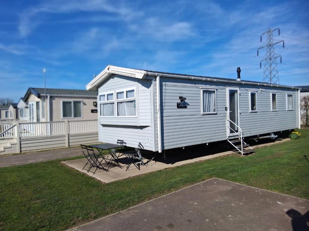 a white trailer with a picnic table and a house at My Spacious Kentish 3-Room Van in Birchington