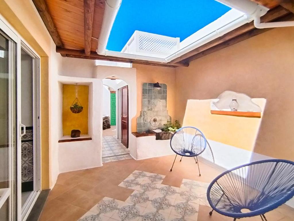 a living room with two chairs and a skylight at Casa MaCló Tranquilidad y autenticidad in Máguez
