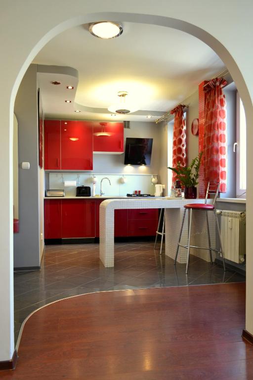 a kitchen with red cabinets and a white counter top at Apartament Piast w Rynku in Nysa
