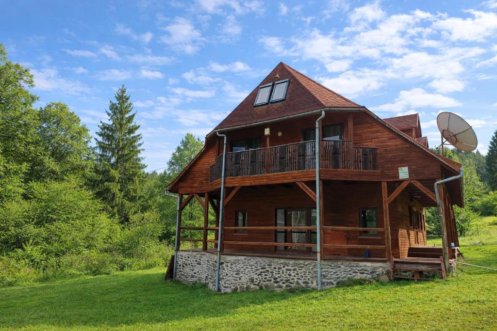 a large wooden house with a satellite at Everwood Lodge, Transylvania in Sub Cetate