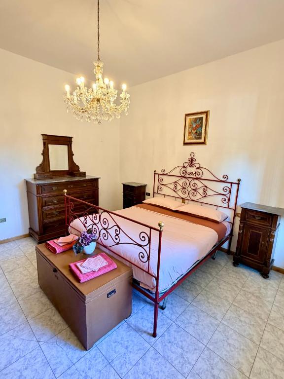 a bedroom with a bed and a table and a chandelier at House of Arcadia in Pistoia