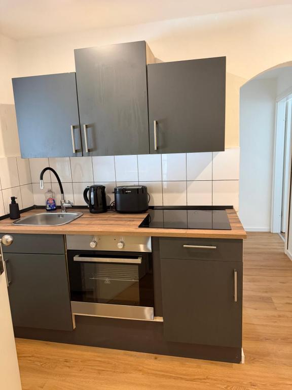 a kitchen with black cabinets and a sink at Tuvalu in Remagen