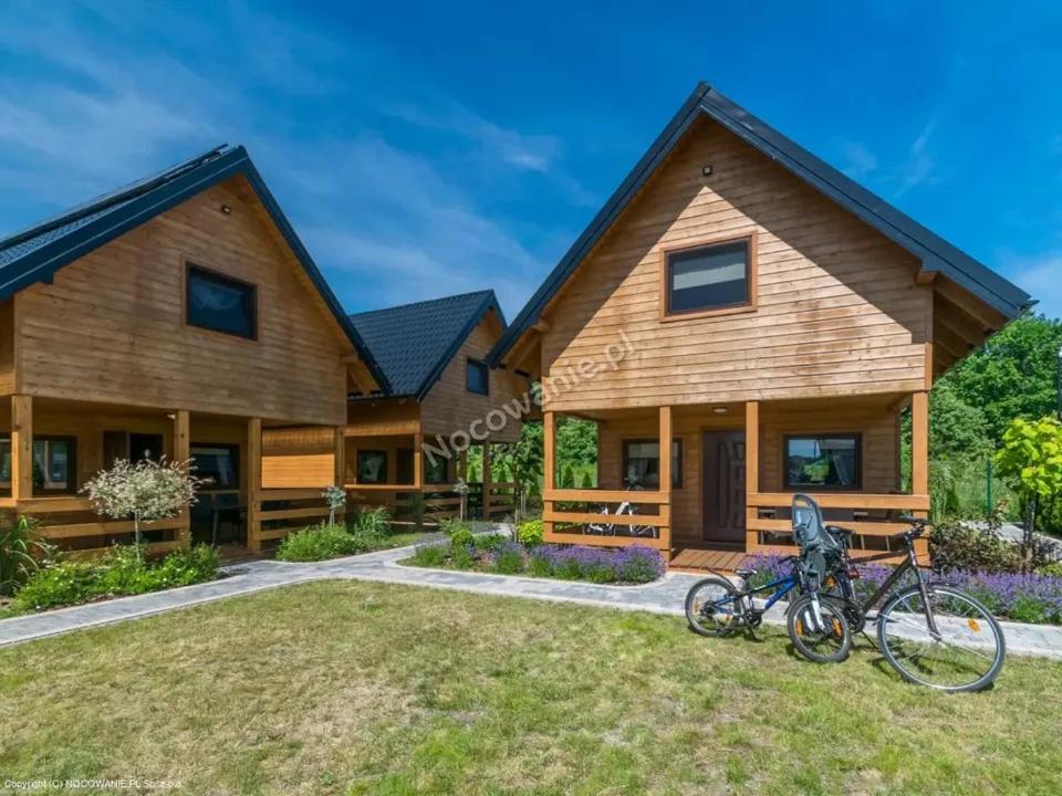 a house with two bikes parked in front of it at Domki Michelle Nad Morzem in Pleśna