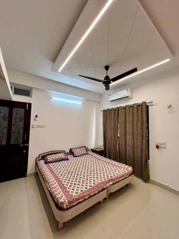 a bedroom with a bed and a ceiling fan at Nisarg Homestay with Kitchen Dinning in Bhuj