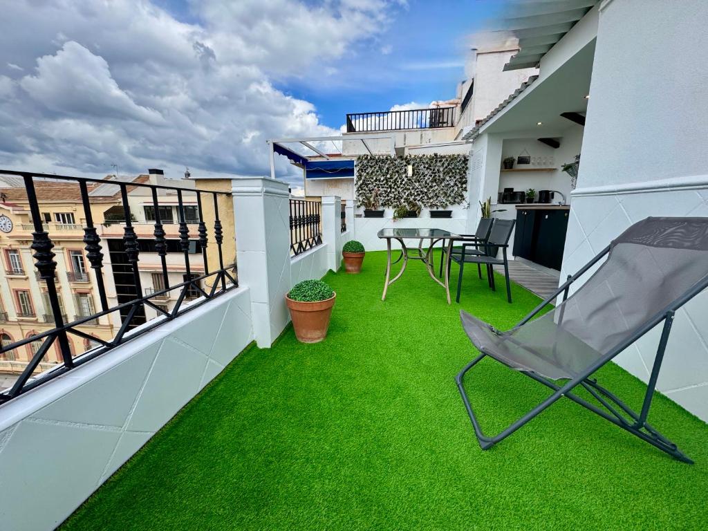 a balcony with green grass and a table and chairs at Mini Estudio Málaga in Málaga