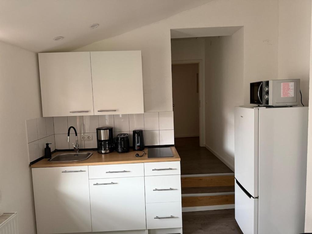 a kitchen with white cabinets and a white refrigerator at Arcadia in Remagen