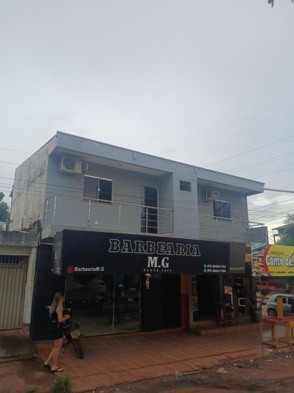 a woman walking in front of a building at Pousada JC 50 in Santarém