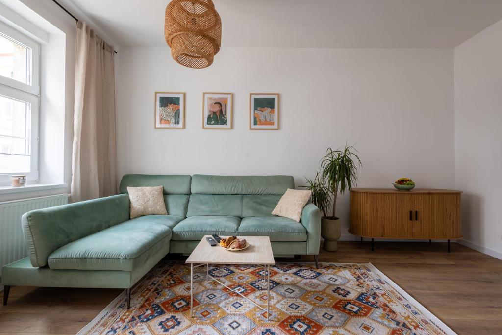 a living room with a green couch and a table at Apartament Miętowy Kwidzyn in Kwidzyn