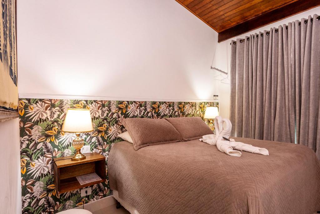 a bedroom with a bed with a stuffed animal on it at Chalés Kalimmera in Ilhabela