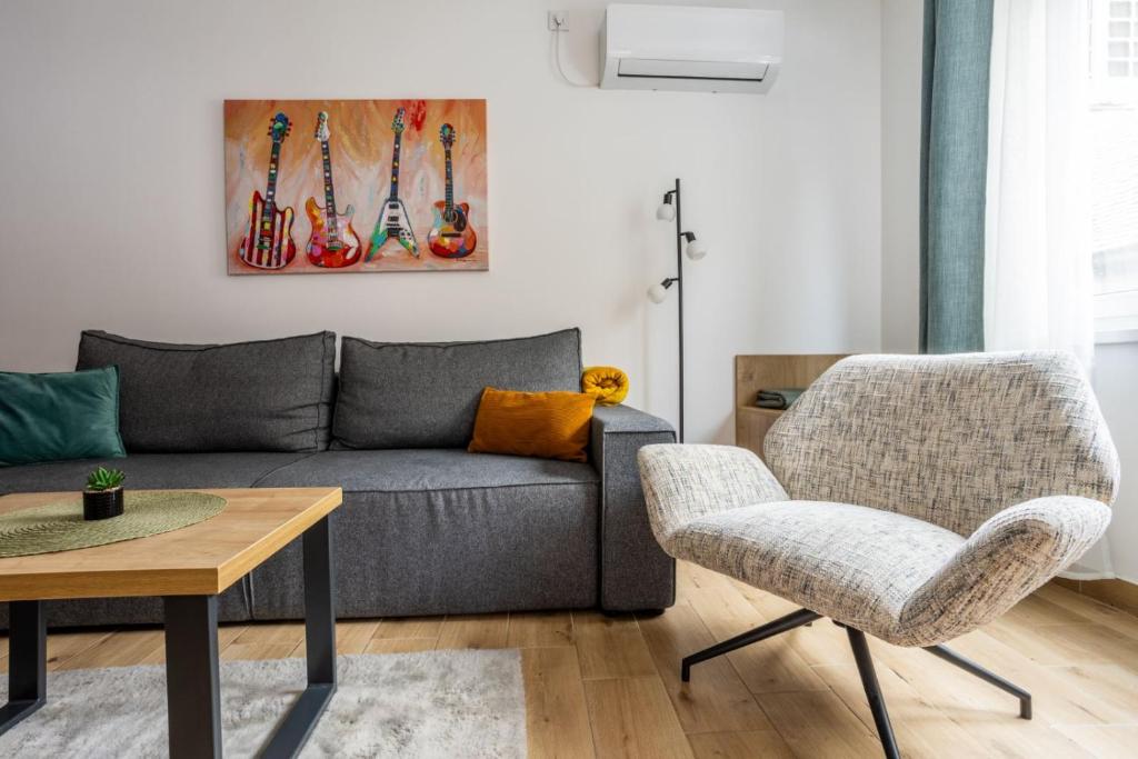 a living room with a couch and a chair at Surčin Central Stay in Surčin