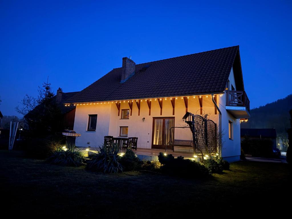 a house with lights on the side of it at night at Klakierówka in Piechowice