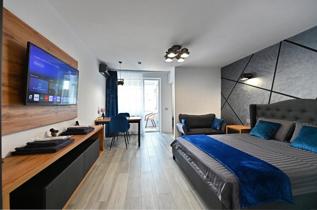 a bedroom with a bed and a desk with a tv at Lili's Studio 2 in Piteşti