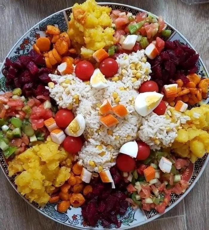 a plate of rice and vegetables on a table at dar elkarzabi in Zagora
