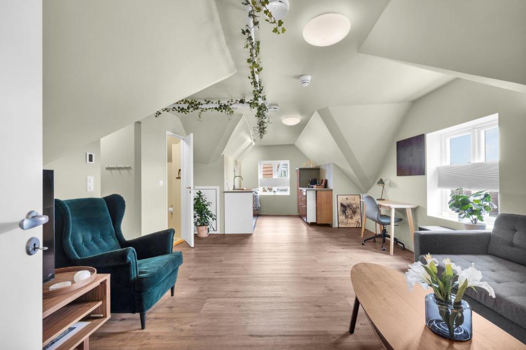 a living room with two blue chairs and a table at Central Top Floor Apartment in Stavanger