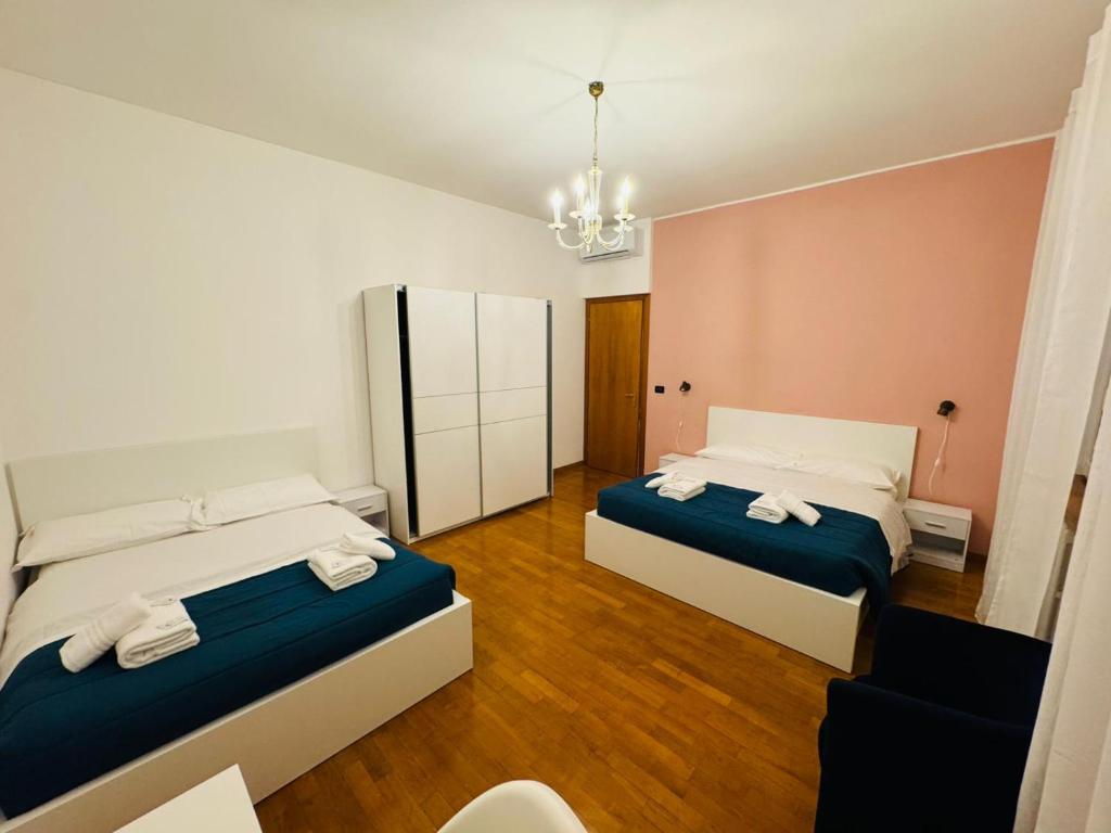 a bedroom with two beds and a chandelier at MMM HOME Train Station 3 in Mestre