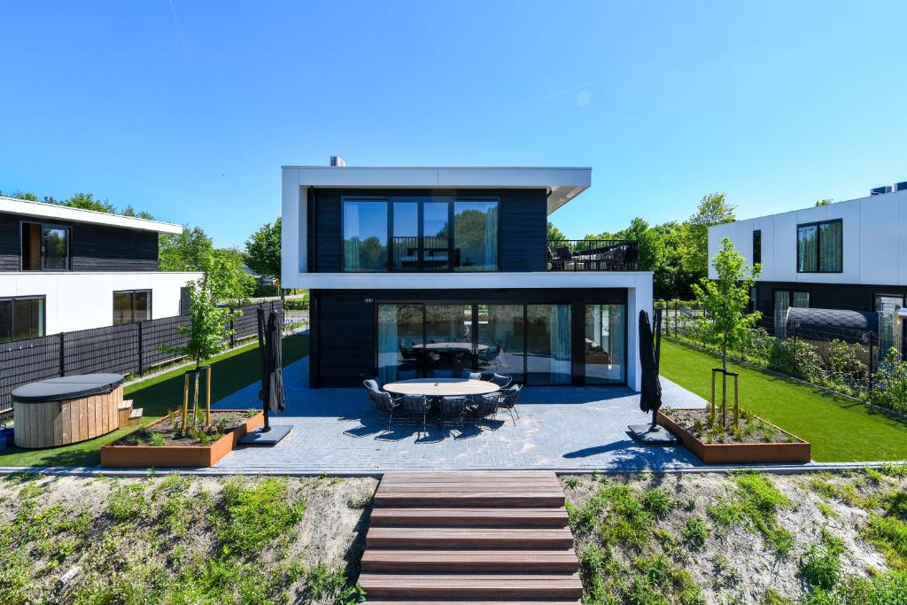 a house with a view of the backyard at Maan Nr. 301 | 10 Pers. Hottub in Zeewolde